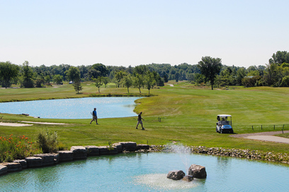 image of people playing golf, walking by water on a golf course